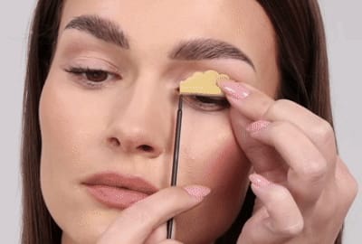 Model melepaskan batang dari kelopak matanya dan bulu matanya dengan lembut